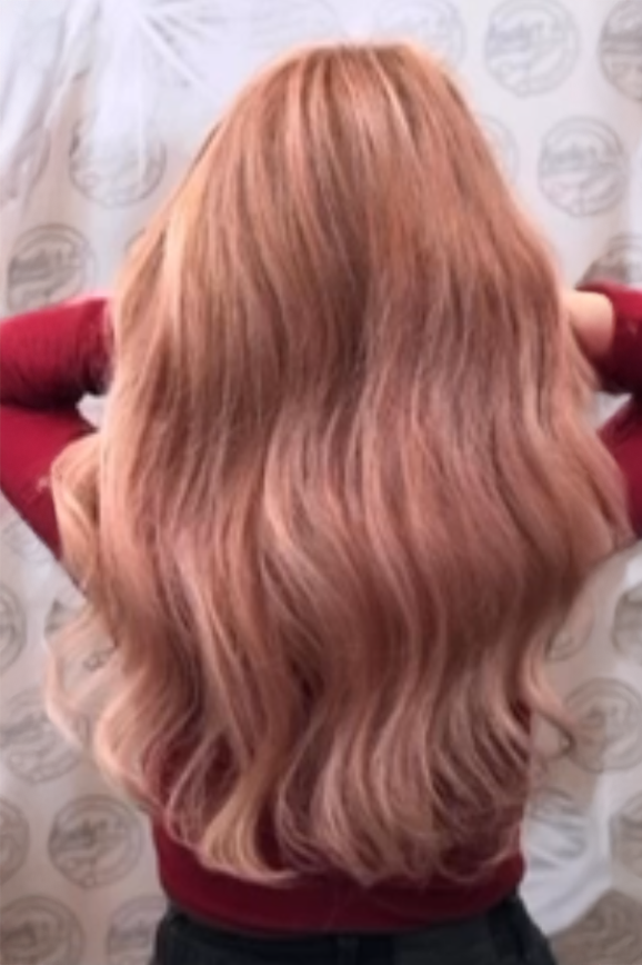 Ergebnis einer Haarverlängerung bei einer Kundin mit langen, braunen Haaren.