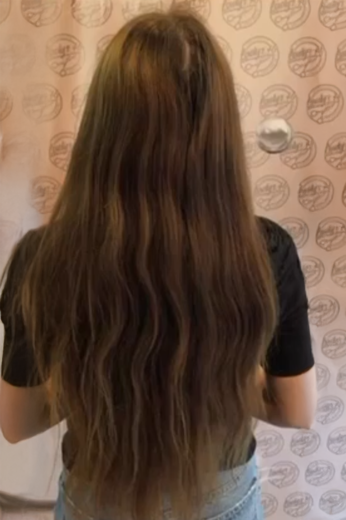 Vorher-Bild einer Kundin mit dunklem, mittellangem Haar